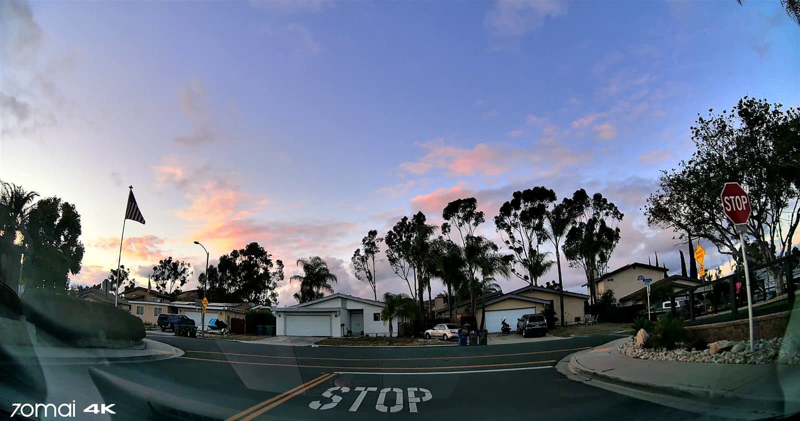 Golden-hour dashcam frame from a fleet vehicle on a residential street