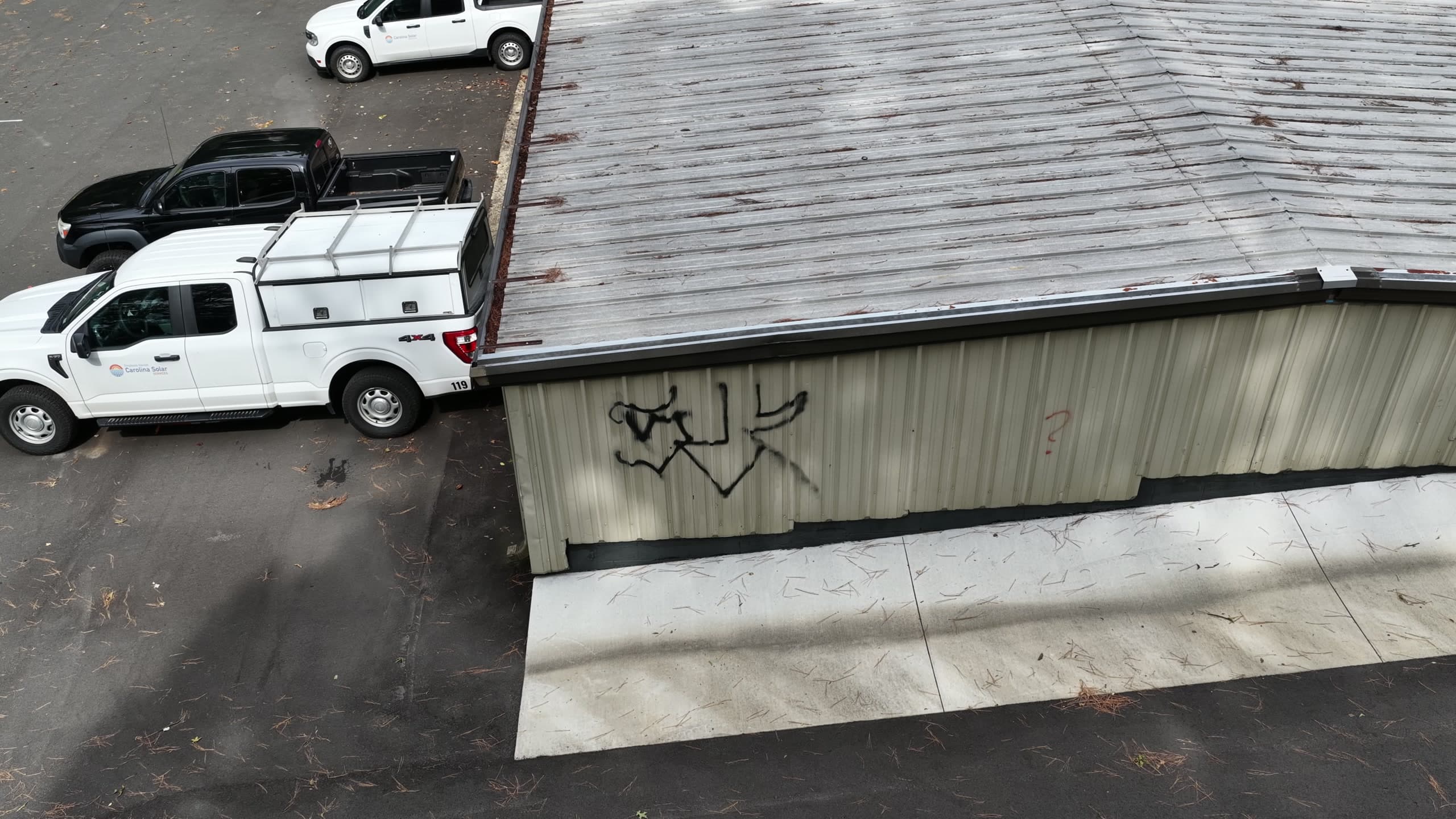 Spray-paint tag on a building, flagged as vandalism